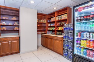 Zona de venta automática con aperitivos y bebidas, que incluye diversas opciones de comida envasada y un dispensador refrigerado.