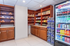 A snack and drink vending area with various packaged snacks and a refrigerated drink dispenser.
