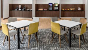 A hotel lobby with a reception desk, seating area, and vending machines. - Fairfield Inn & Suites Calhoun (Calhoun)