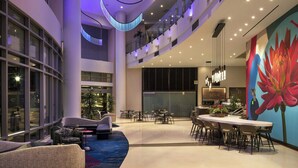 A spacious lobby with a central seating area, a dining table, and a large flower mural. - Residence Inn Los Angeles L.A. LIVE (Los Angeles)