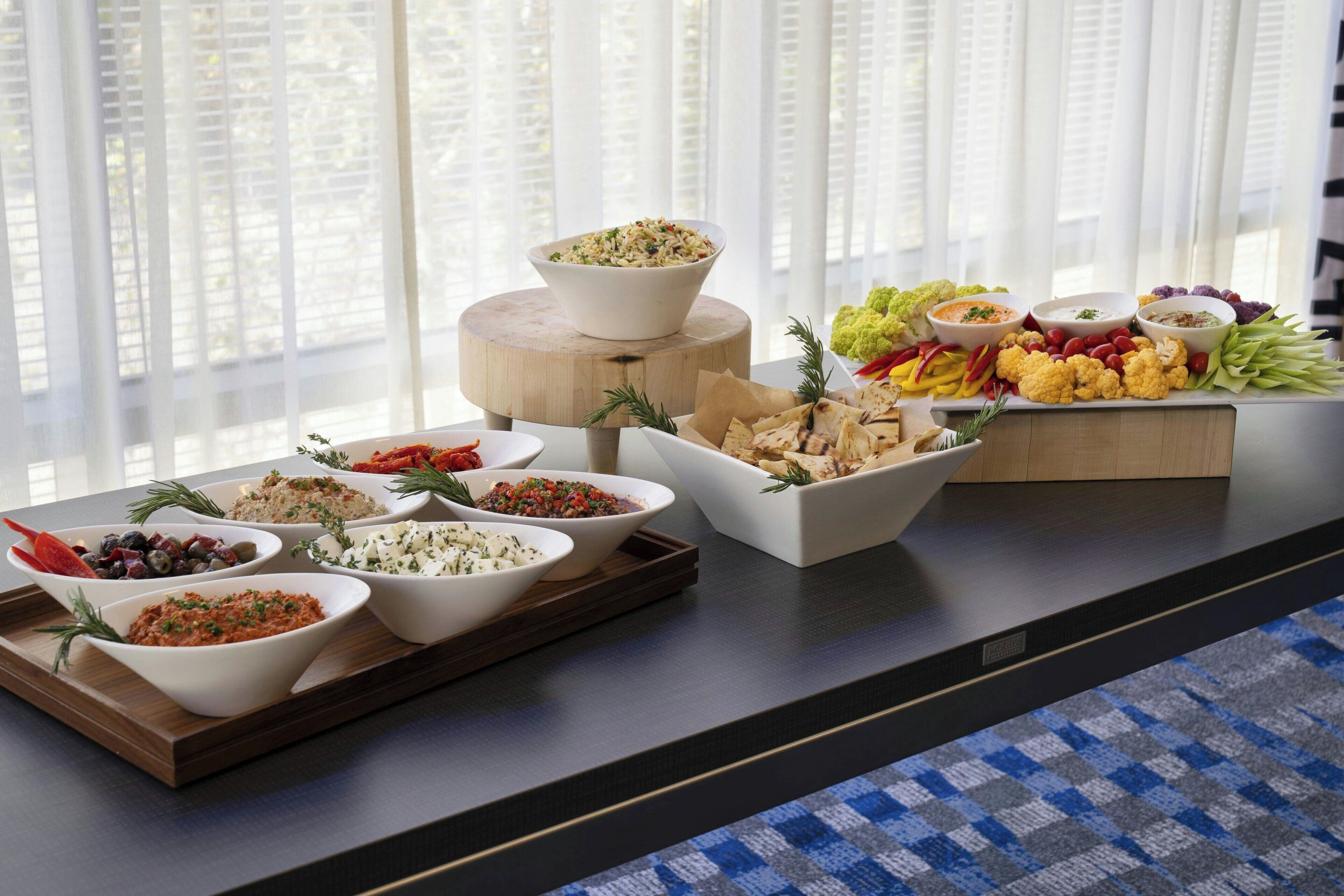 A buffet table with various dishes and garnishes.