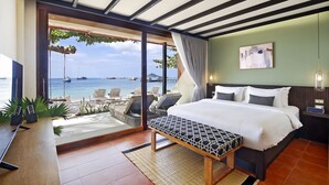A hotel room with a bed, a bench, a desk, and a view of the sea. - Lücke Boutique Hotel (Koh Tao)
