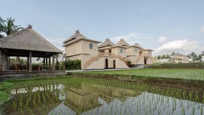 A resort with multiple buildings, a thatched-roof pavilion, and a rice paddy field. - Manyi Village (Ubud)
