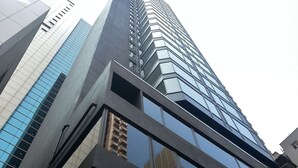 A high-rise building with a modern glass facade and a geometric design. - Brighton Hotel Hong Kong (Hong Kong)