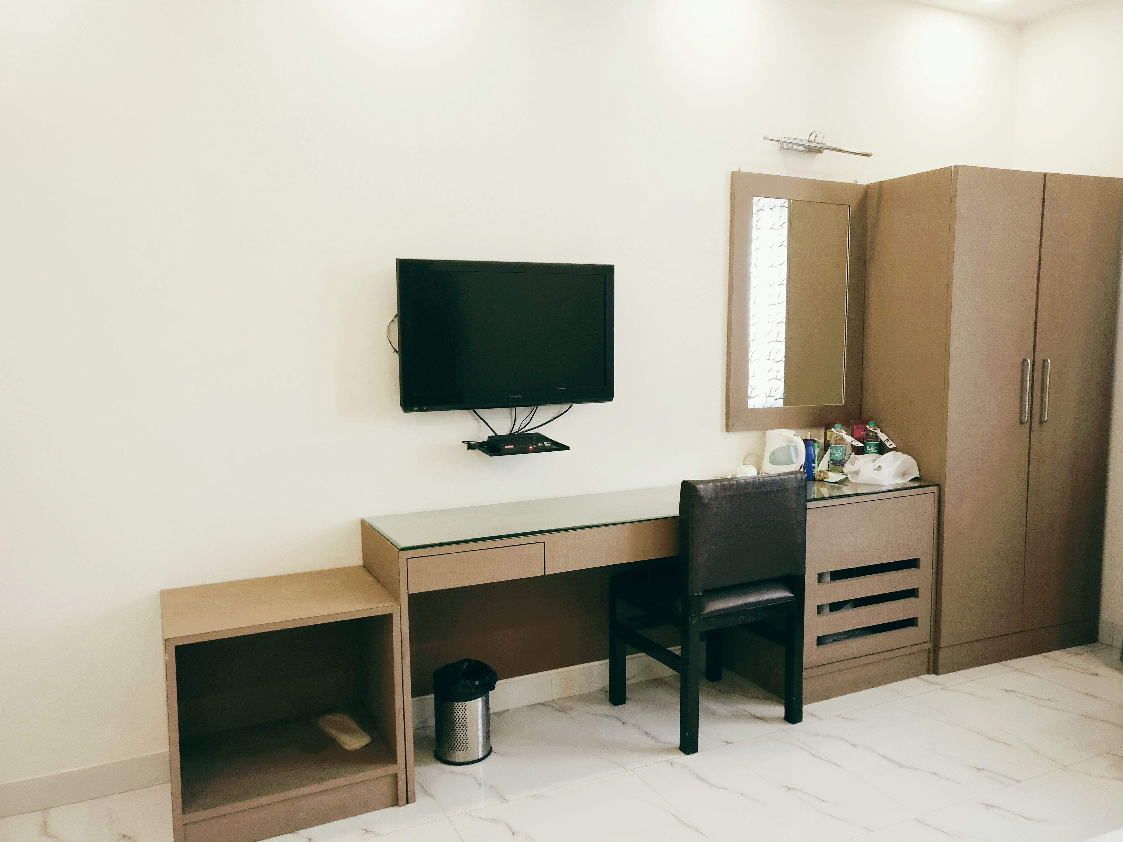 Ein Schlafzimmer mit einem Bett, einem Schreibtisch mit Stuhl, einem Fernseher und einem Kleiderschrank.