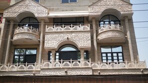 Un edificio de varios pisos con balcones decorados y ventanas amplias.