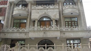 Un edificio de varios pisos con balcones decorados y ventanas grandes.