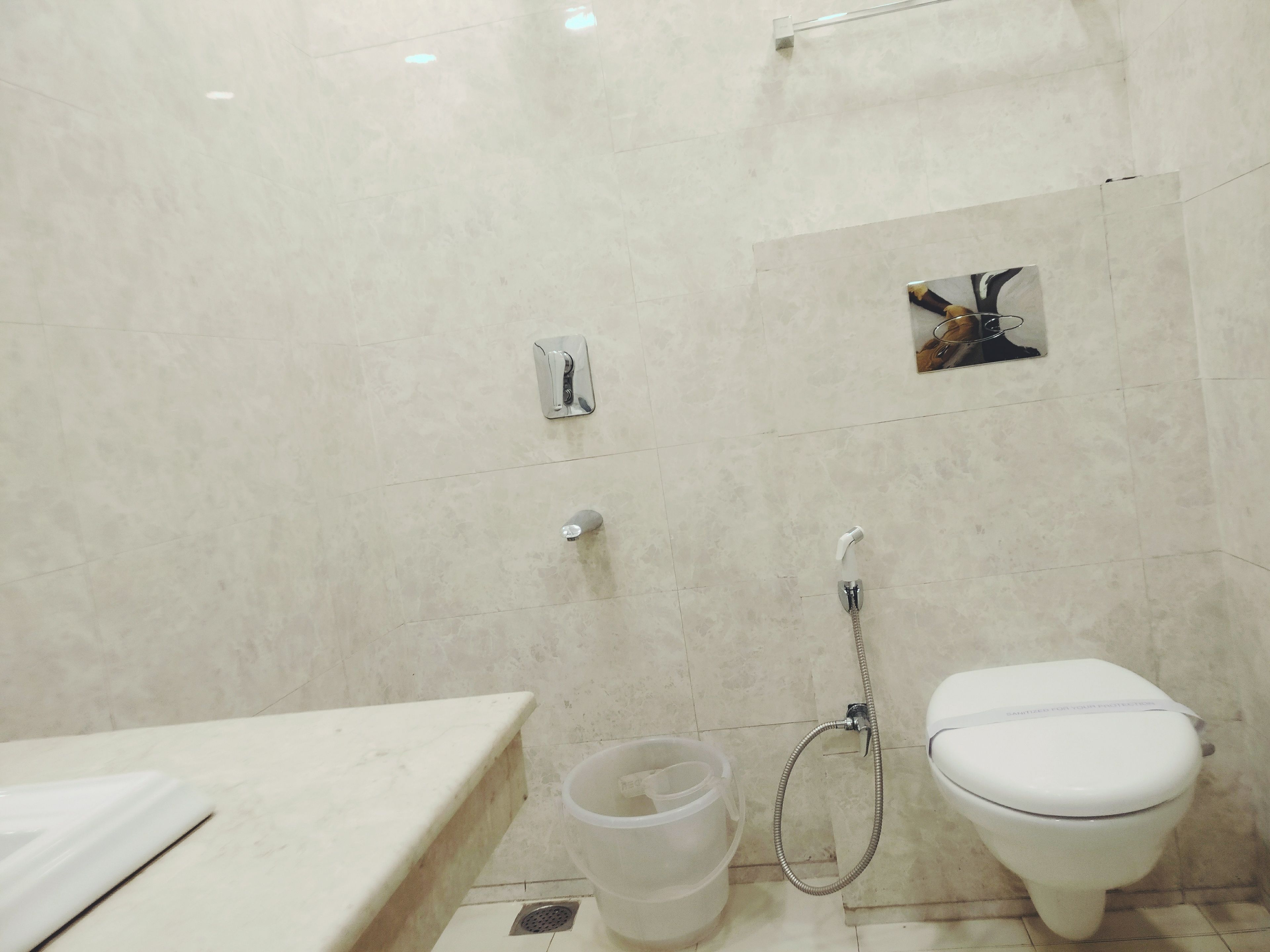 A bathroom with a toilet, a shower, and a sink.