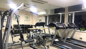 A gym with treadmills, a weight bench, and a mirror. - Sun Moon Lake Hotel (Dalian)