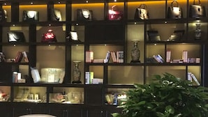 A display of handbags and books on shelves in a room. - Sun Moon Lake Hotel (Dalian)
