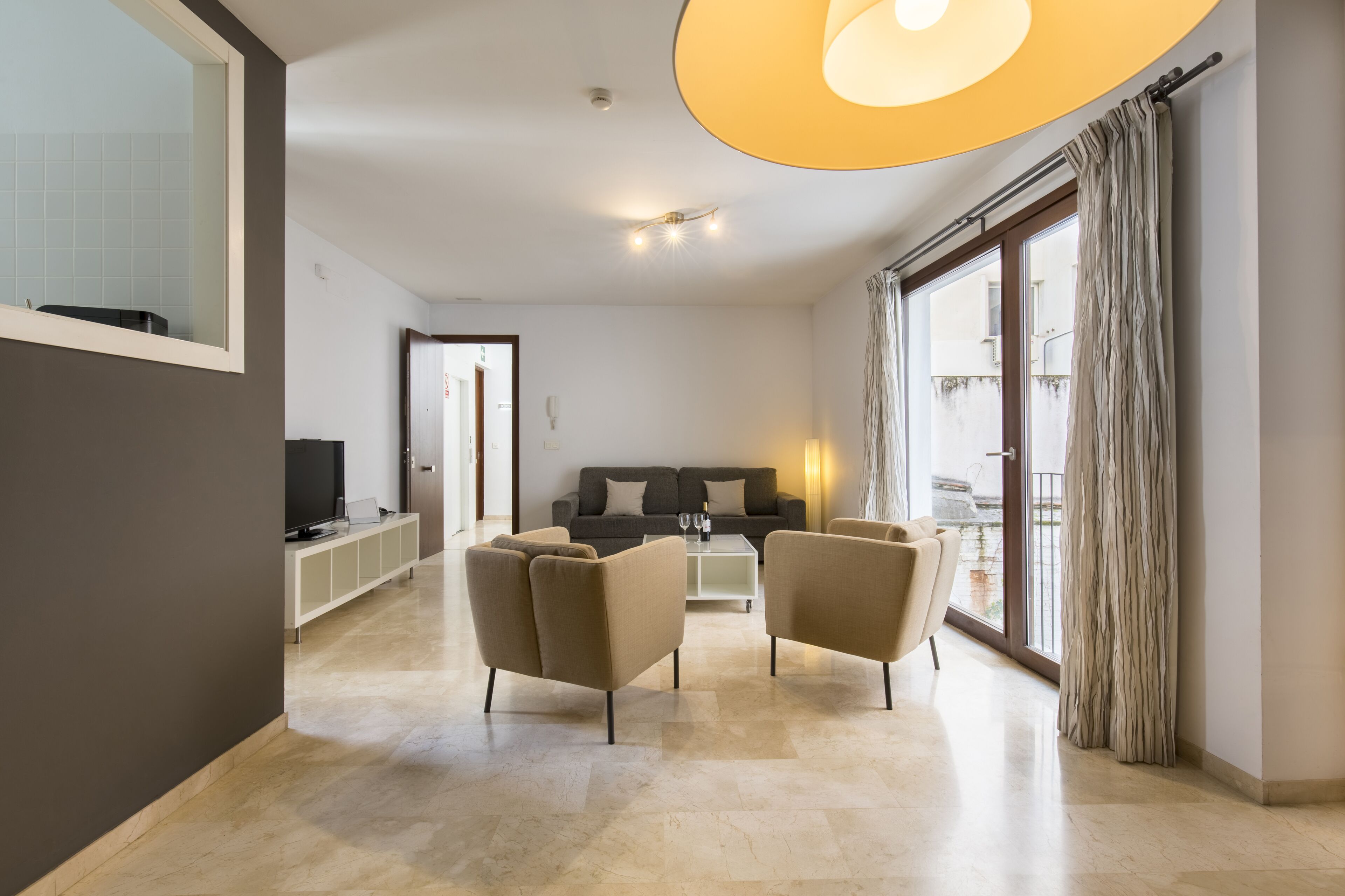 Una sala moderna con un sofá, una mesa de centro y un televisor.