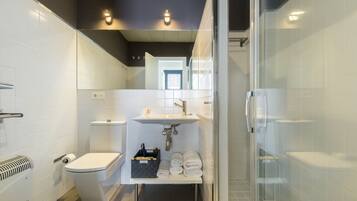 Een moderne badkamer met toilet, wastafel en douche.