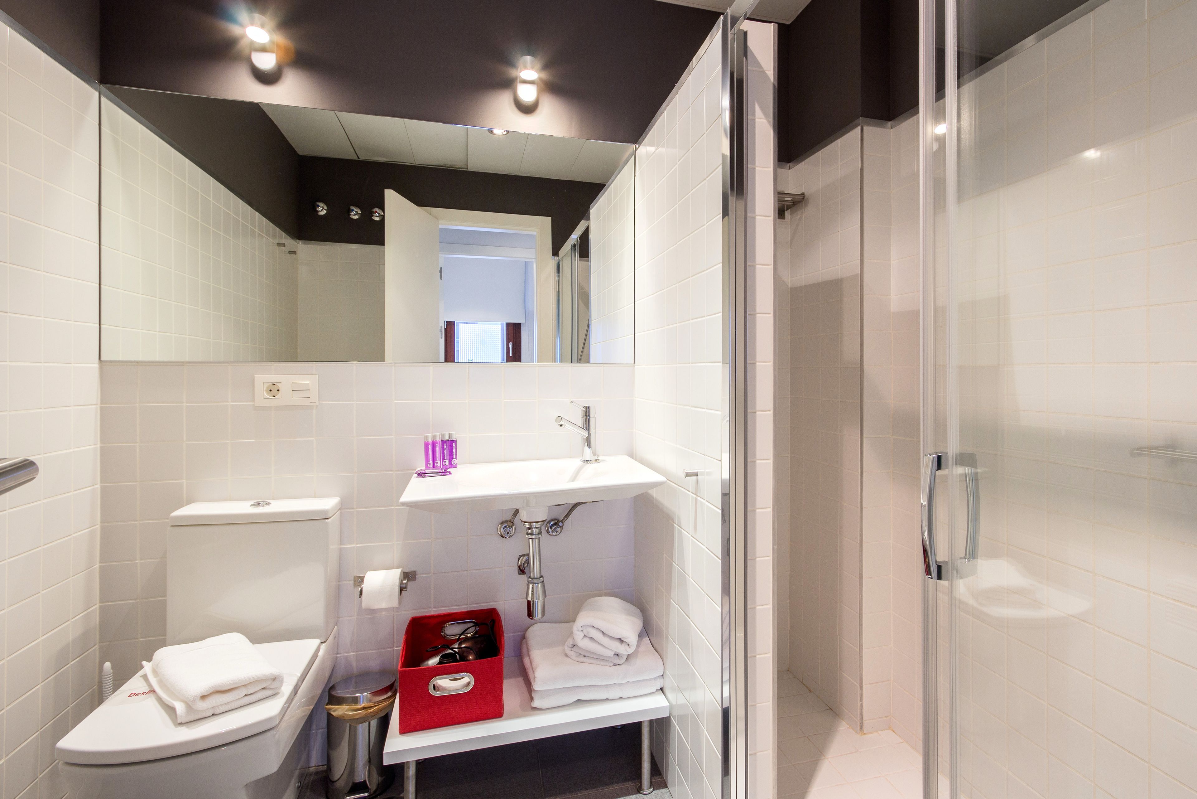 A modern bathroom with a toilet, sink, and shower.