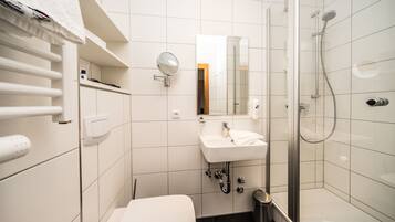 A modern bathroom with a toilet, sink, and shower.
