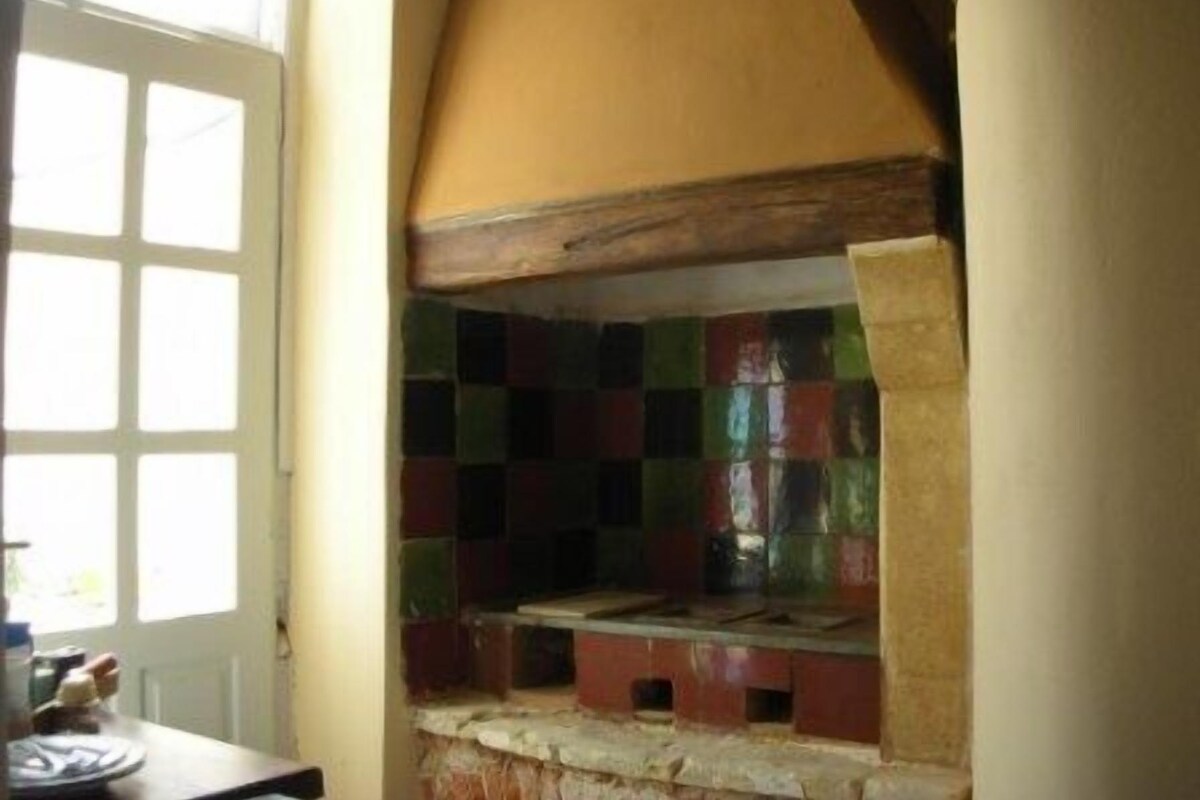 A kitchen with a checkered backsplash, a window, and a door.