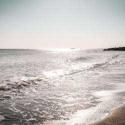On the beach, black sand, sun-loungers, beach umbrellas