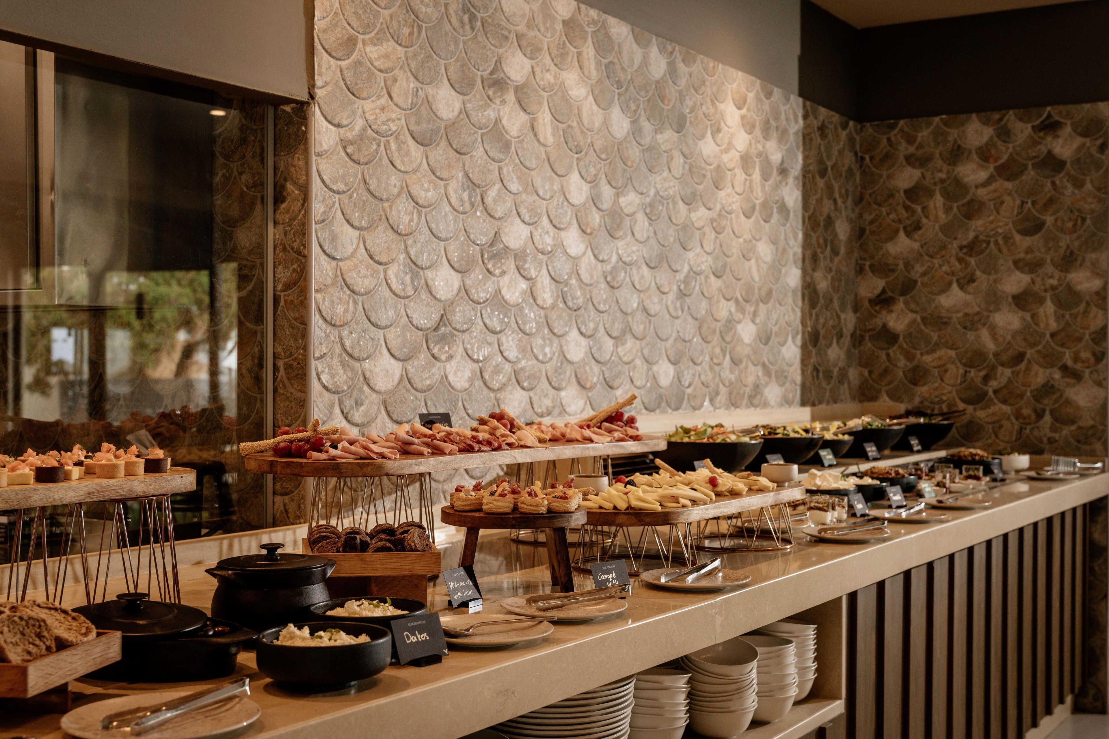 Un'imbandiglia di cibi e piatti a buffet.