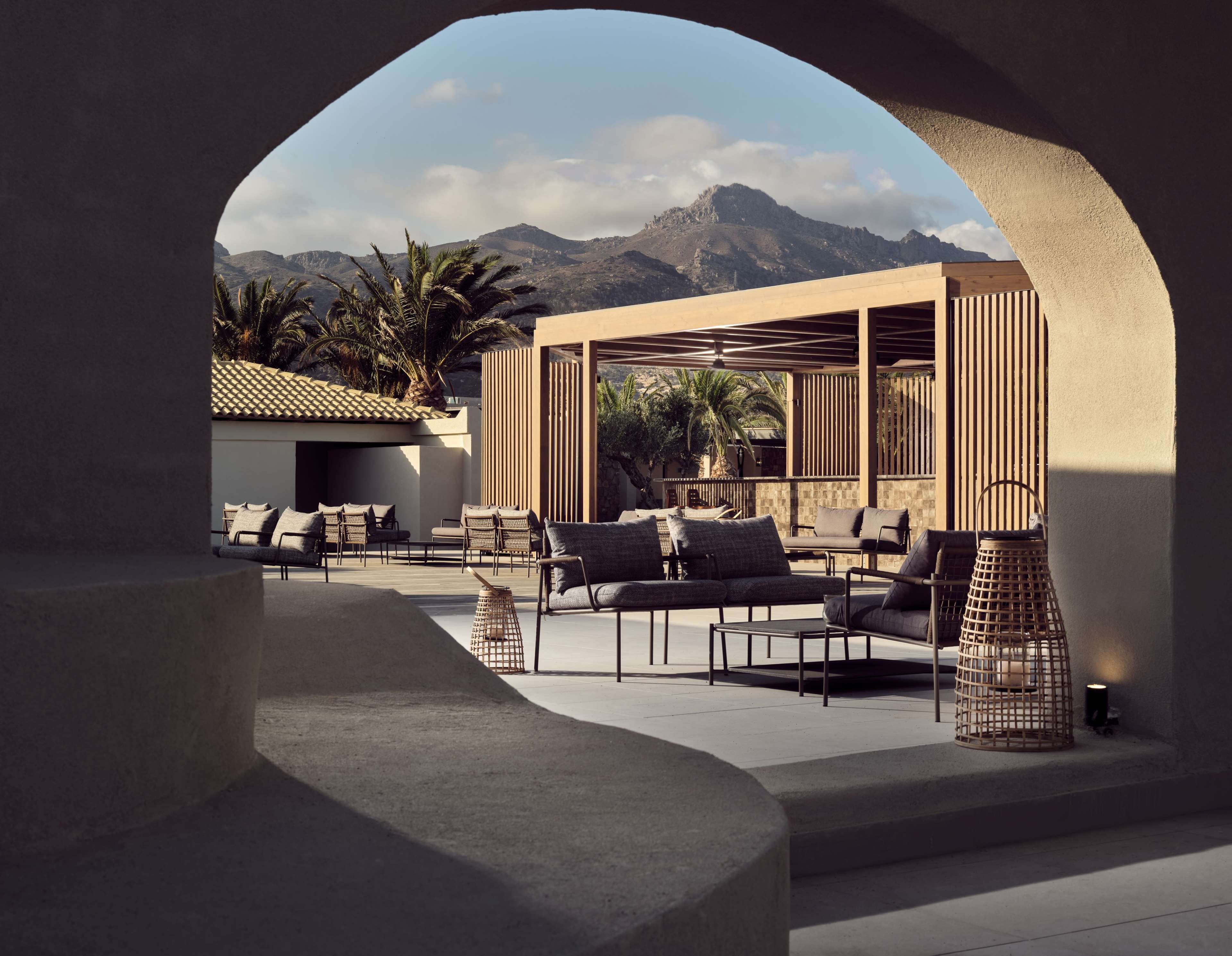 A modern outdoor patio with seating and a view of mountains.