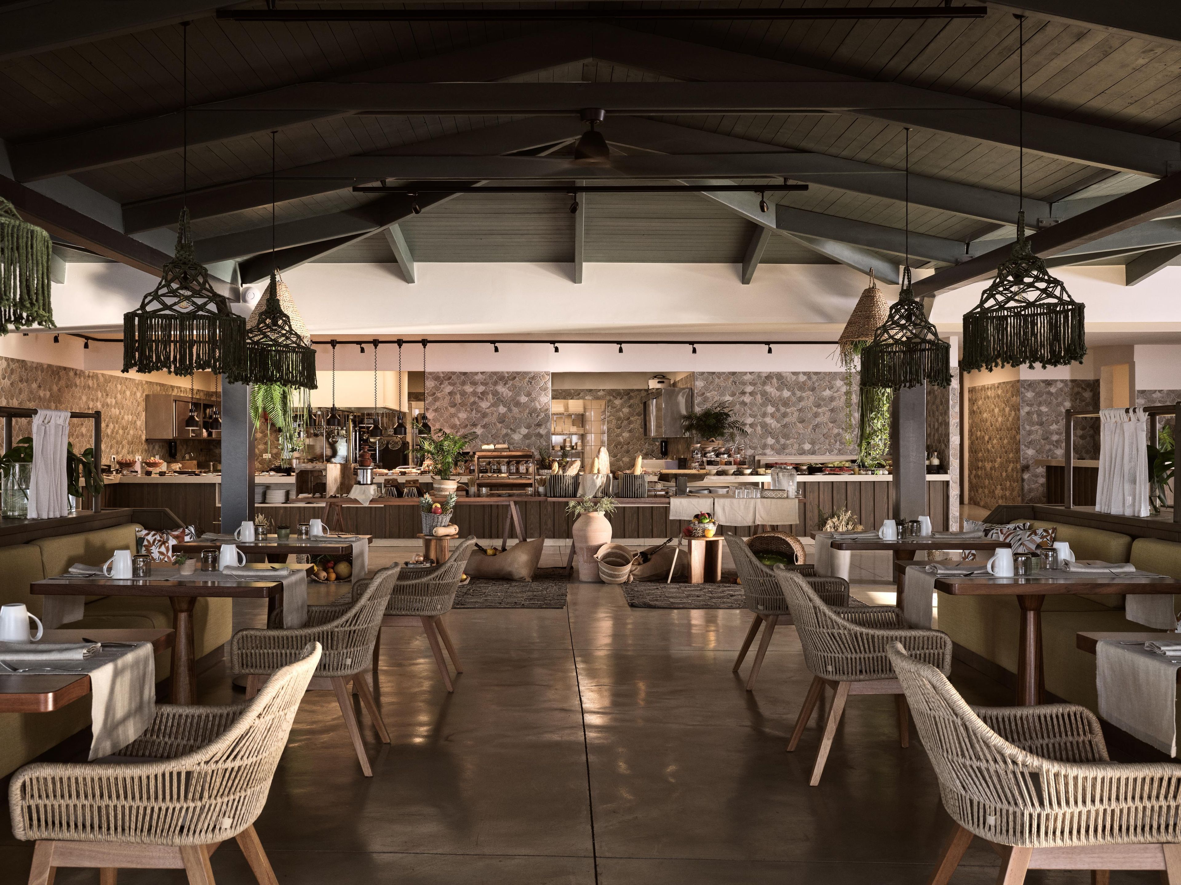 A spacious outdoor dining area with wicker furniture and hanging lights.
