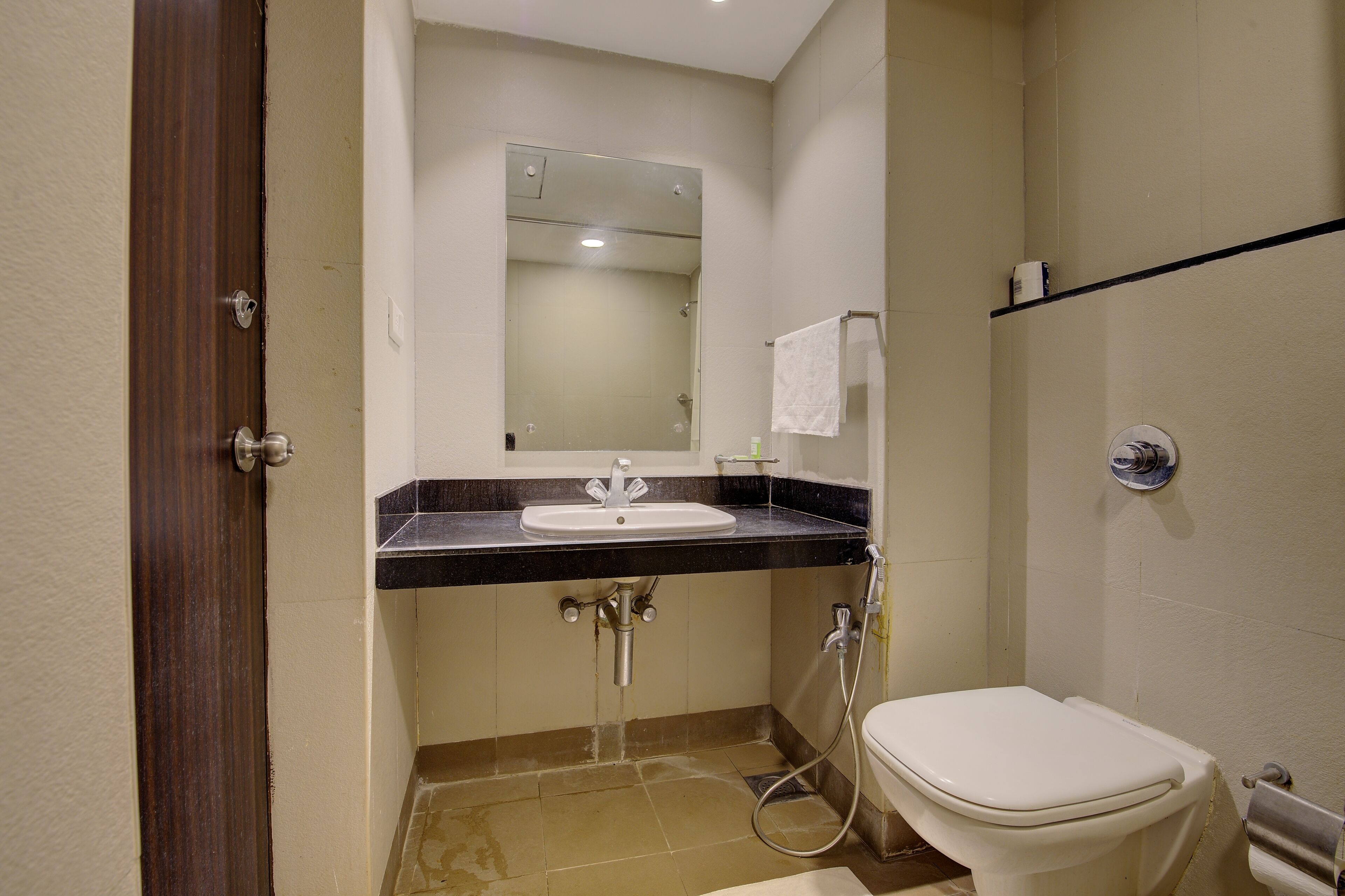A bathroom with a sink, mirror, toilet, and shower.