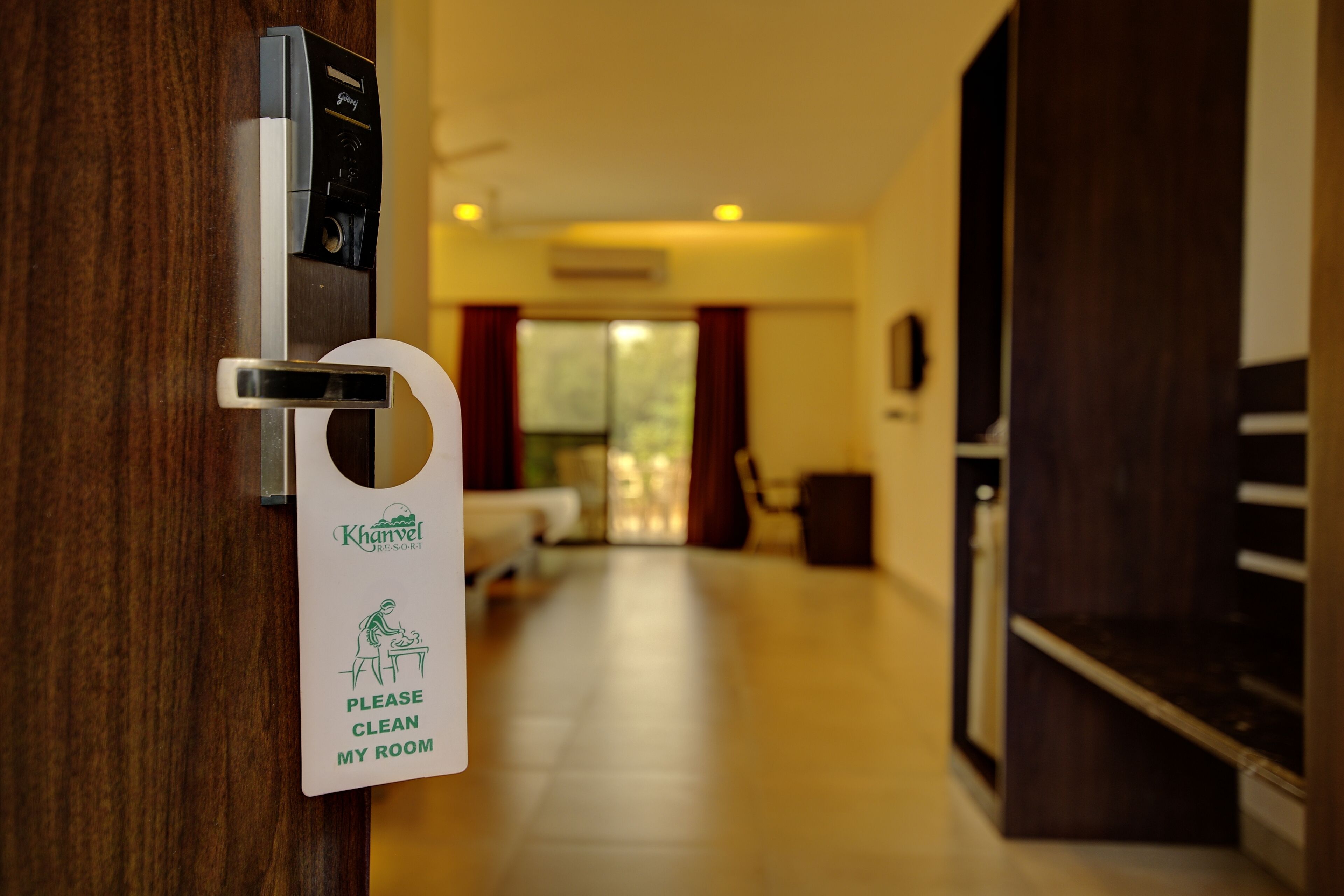 A hotel room door with a keycard reader and a sign instructing to clean the room.