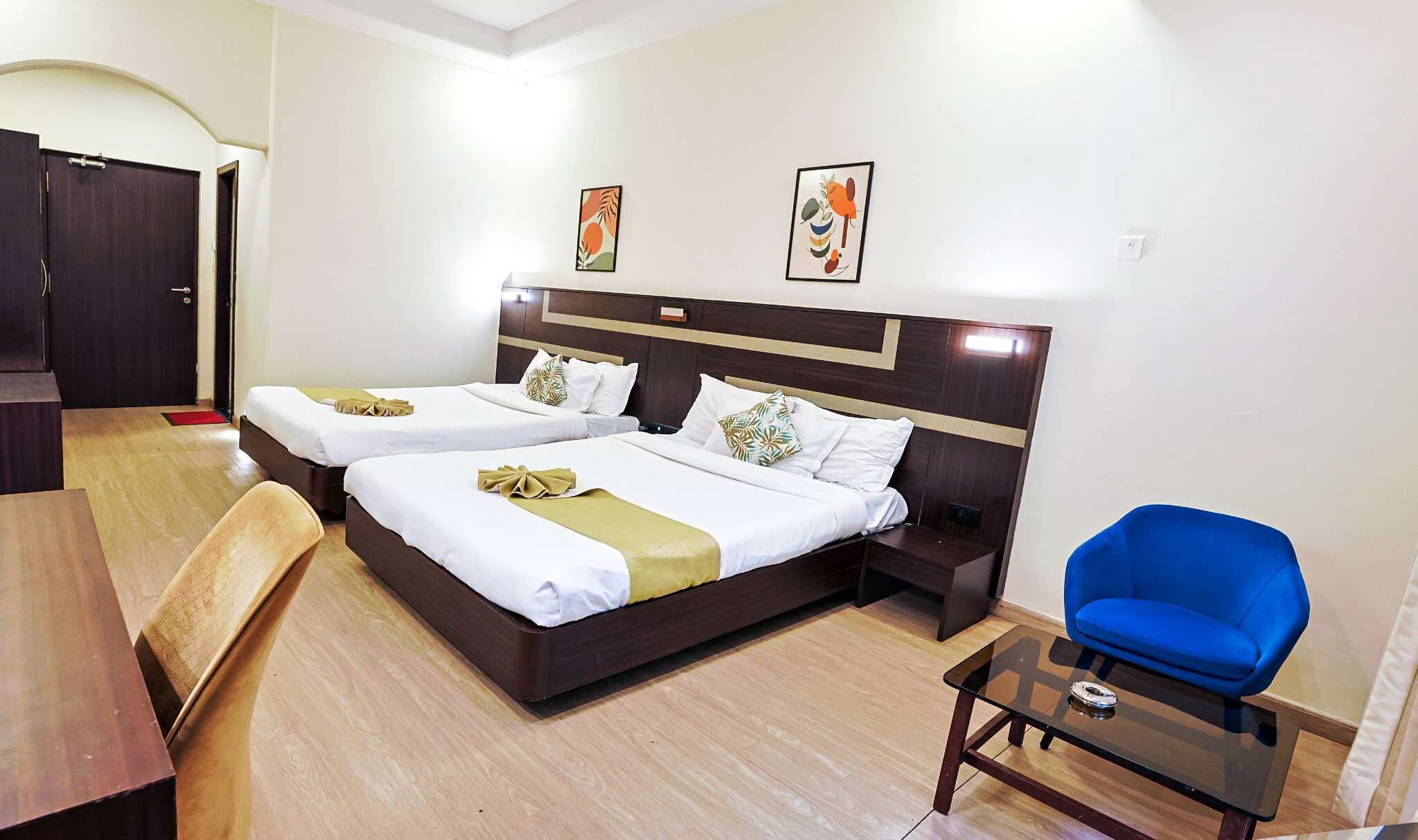 Ein Hotelzimmer mit einem großen Bett, einem Schreibtisch, einem Stuhl und zwei Bildern an der Wand.