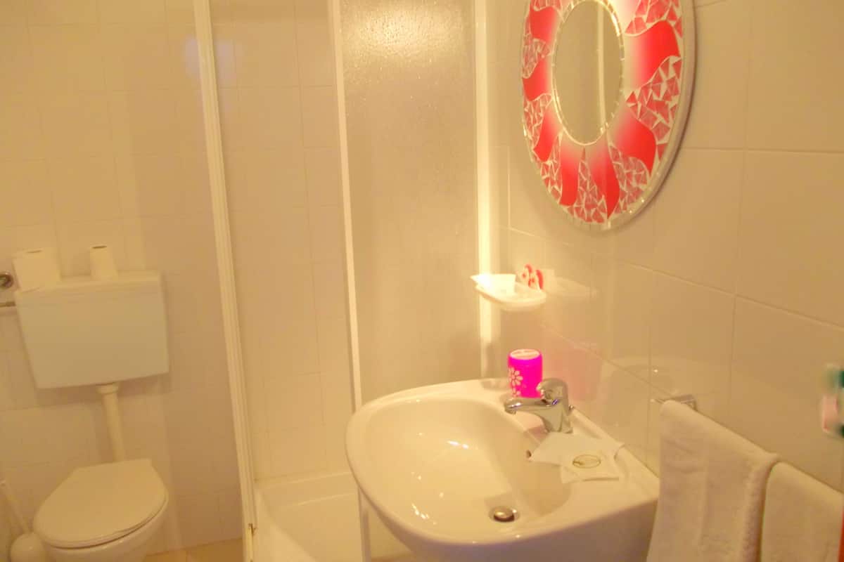 A bathroom with a toilet, sink, and shower.