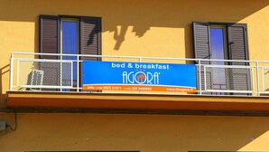 A balcony with a sign advertising bed and breakfast services, contact information, and a website URL.