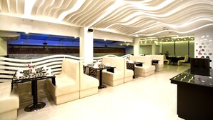A modern lounge area with a unique ceiling design, comfortable seating, and a bar area. - Innotel Luxury Business Hotel (Dhaka)