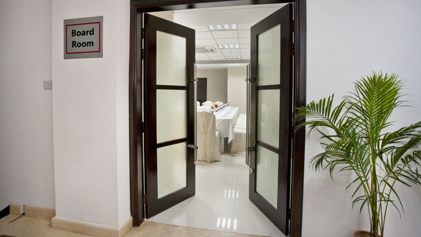 A board room with a sign, a potted plant, and a table with chairs. - Innotel Luxury Business Hotel (Dhaka)