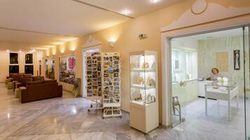 A hotel lobby with seating areas, a jewelry display, and a reception desk.