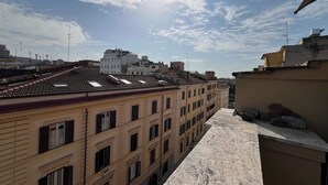 A rooftop terrace with a view of surrounding buildings and the sky. - Freedom Traveller Hostel (Rome)