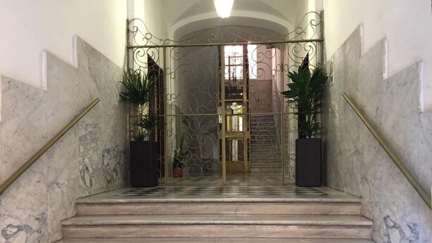 A marble staircase with a wrought iron gate leading to a room. - Freedom Traveller Hostel (Rome)