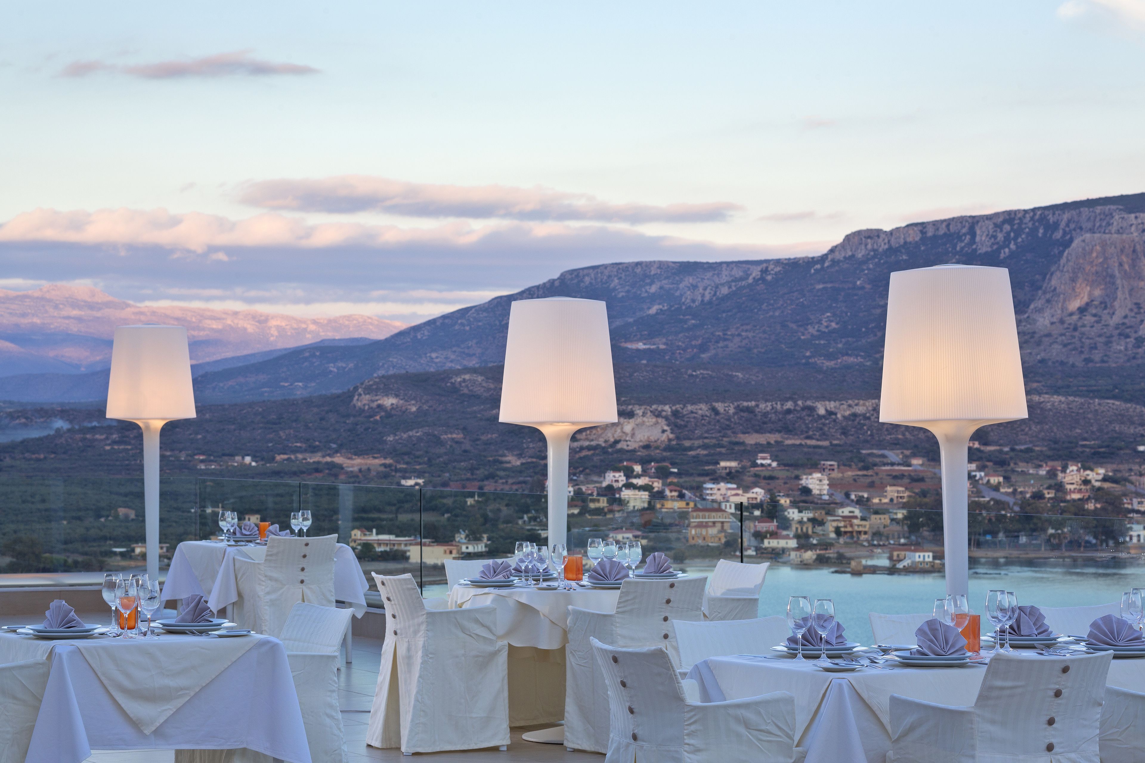 Un espace repas avec des tables dressées pour le service, offrant une vue sur un paysage montagneux.