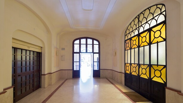 A hallway with a marble floor, a large arched doorway, and a decorative glass window on the right. - B&B A Picture of Rome (Rome)
