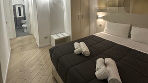 A modern hotel room with a large bed, a wardrobe, and a bathroom visible through an open door. - B&B A Picture of Rome (Rome)