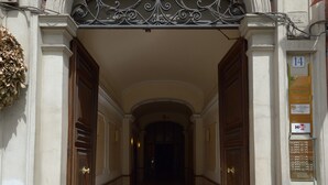 An entrance with a decorative metal archway, a potted plant with flowers, and a sign with the number 14. - B&B A Picture of Rome (Rome)
