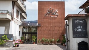 Hotel La Villette with a prominent sign, a modern entrance, and potted plants in front. - Hotel La Villetta (Calenzano)