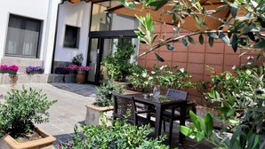 An outdoor patio area with a table and chairs, surrounded by potted plants and flowers. - Hotel La Villetta (Calenzano)