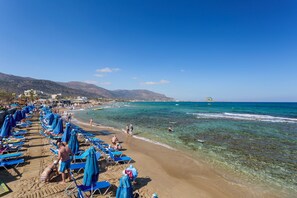 Sur la plage, chaise longue, parasol, serviettes de plage
