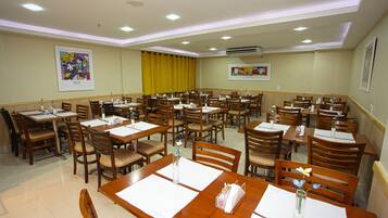 A dining area with multiple tables and chairs, arranged in rows.