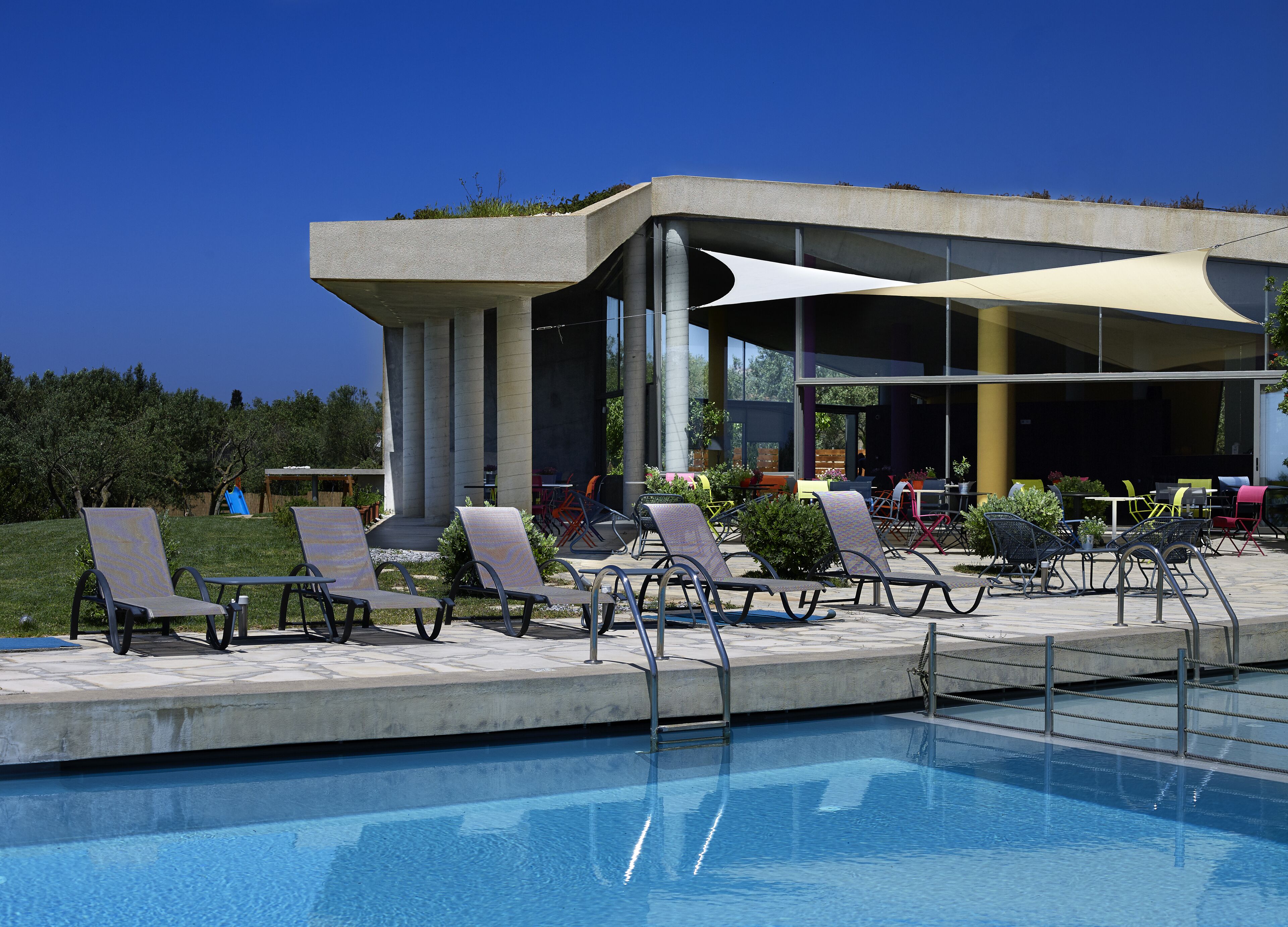 A poolside area with lounge chairs and a covered seating area.