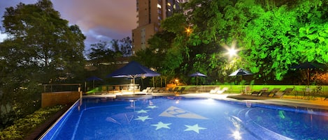 Una piscina al aire libre, sombrillas