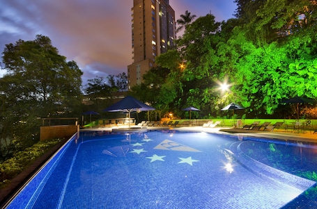 Una piscina al aire libre, sombrillas