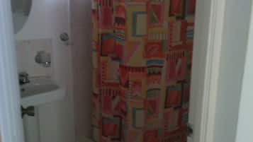 A small bathroom with a toilet, sink, and shower curtain.