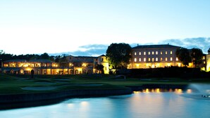 Un campo de golf con un edificio grande al fondo.