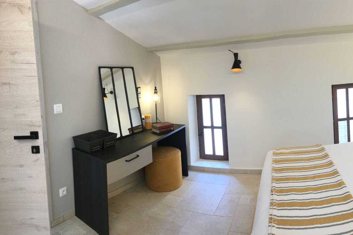Une chambre à coucher avec un lit, des tables de chevet, un bureau et une chaise.