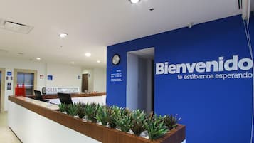 Een receptiebalie met een blauwe muur en een klok erboven.