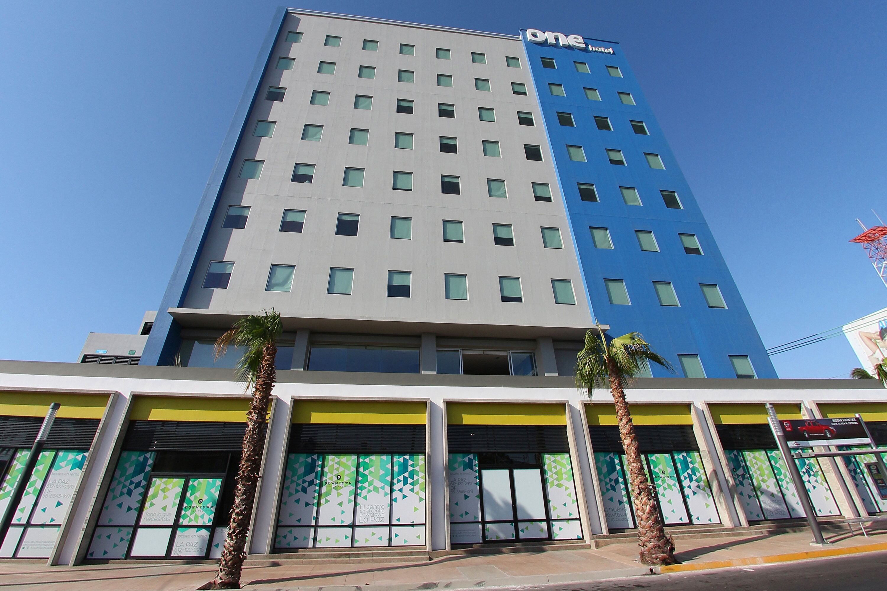 A multi-story hotel with a modern design, featuring a prominent 'one hotel' sign on the top.