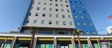 A multi-story hotel with a modern design, featuring a prominent 'one hotel' sign on the top.